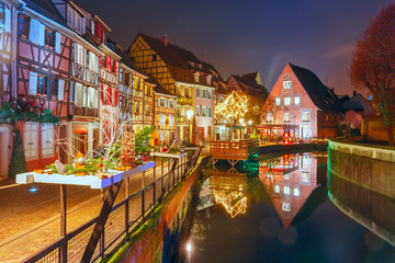 Traditional Alsatian half-timbered houses in Petite Venise or little Venice, old town of Colmar, decorated and illuminated at snowy christmas night, Alsace, France