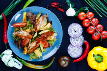 Delicious fresh salad with smoked eel and pineapple slices, flat lay on dark background with ingredients.  Pan-Asian, oriental cuisine, tasty appetizing seafood