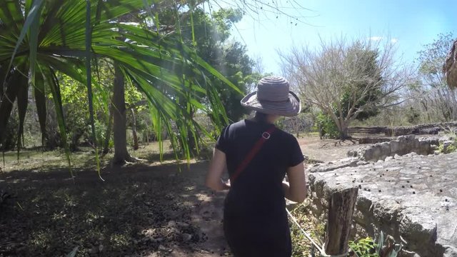 Gimbal shot of tourist woman walking in Ek Balam Mayan Ruins