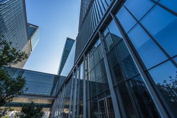 Obraz na płótnie Canvas Bottom view of modern skyscrapers in business district against blue sky.