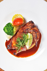 Half of appetizing roasted juicy chicken with lemon slices and  vegetables 
