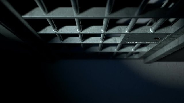 A static camera closeup of a heavy welded iron jail cell door slamming shut on a dark moody background