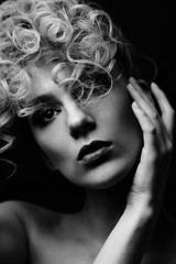 Barber. Black and white portrait of a young girl with stylish curly hairstyle on black background