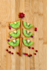 Kiwi fruit Christmas tree dessert on wooden background