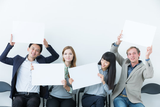 Several people showing white boards.