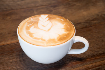 A cup of coffee latte art on wooden table