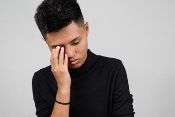 Fototapeta premium Portrait of Asian young tomboy looking sad and worried while thinking