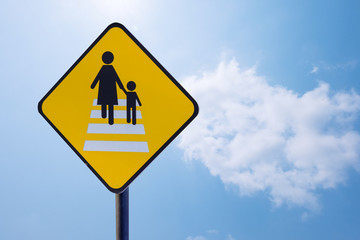 Caution people crossing traffic sign isolated on blue sky background with clipping path included.
