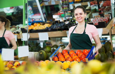 Grocery worker offering persimmons