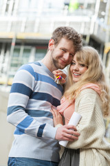 Couple with keys on front of new modern house