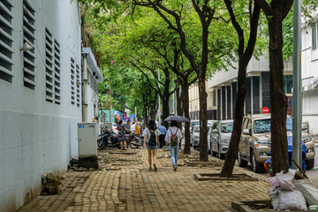 Pedestrian area with girls under sun umbrella in Ho Chi Minh City, Saigon Vietnam.