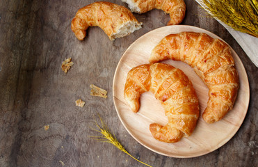 freshly baked croissants on wooden cutting board, top view