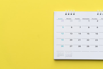 close up of calendar on yellow background, planning for business meeting or travel planning concept - obrazy, fototapety, plakaty