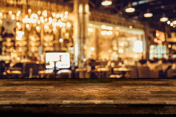 Fototapeta na wymiar Empty wood table top and blur of night pub or restaurant background/selective focus .For montage product display