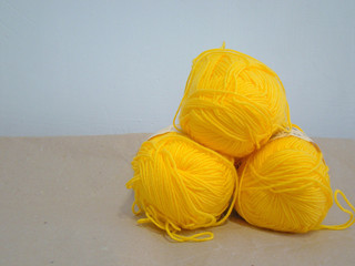 Yellow yarn on a white wall background