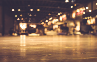 Wood table top with reflect on blur of lighting in night cafe,restaurant background/selective focus.