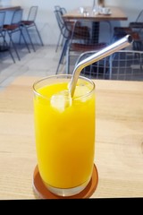 Orange juice in glass with metal straw