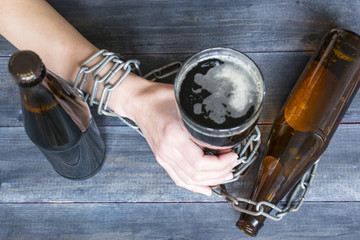 Alcohol addiction concept, glass of beer, bottles, chain and drinking woman.