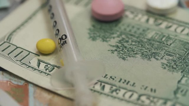 Pills, drugs, cocaine, syringe on dollar bank notes. Dolly shoot..