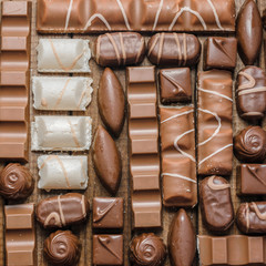 Background of chocolates, bars and sweets, free space for text, close up