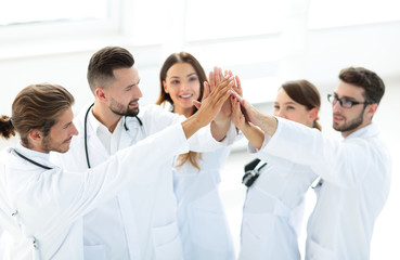 group of doctors giving each other a high five.