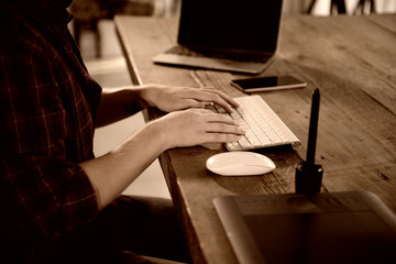 A young man working on a computer in their home.