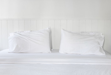 Fototapeta na wymiar White pillow and bedding in modern white bedroom interior