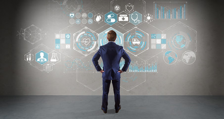 Businessman watching medical interface on a wall 3D rendering