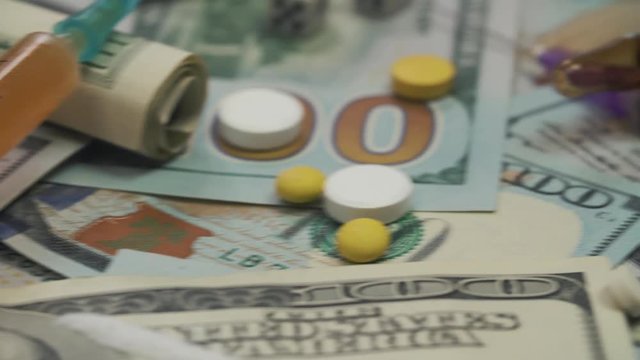 Pills, drugs, cocaine, syringe on dollar bank notes 