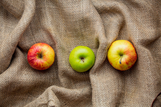 Autumn apples on jute sack background.