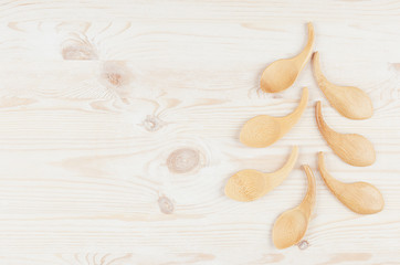 Christmas tree of beige bamboo spoons on white wood board.