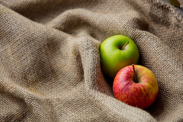 Two autumn apples on jute sack background