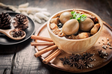 Eggs and pork boiled in the gravy on wooden table, Thai food.