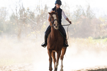 Fototapeta premium Young pretty girl - riding a horse in winter morning