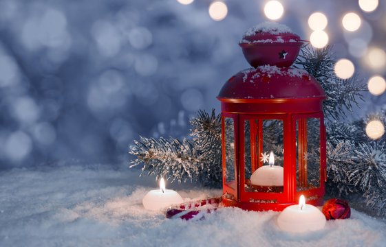 Christmas decorated lantern and candles on snow with copy space