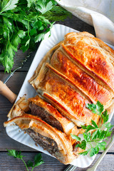 Meat baked with mushrooms in puff pastry, top view, selective focus