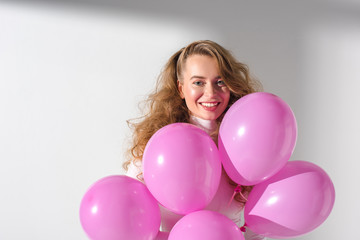 Fototapeta na wymiar beautiful smiling girl with bundle of pink balloons