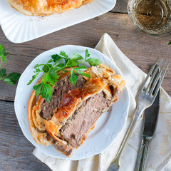 Meat baked with mushrooms in puff pastry, top view, selective focus, square