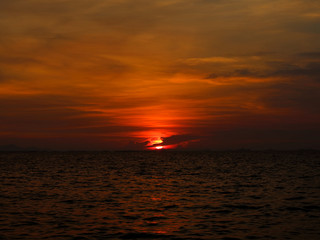sunset last light of sun on horizontal line over dark sky