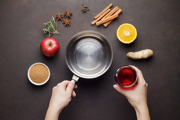 Hands cook mulled wine from ingredients on brown table. - 182667222