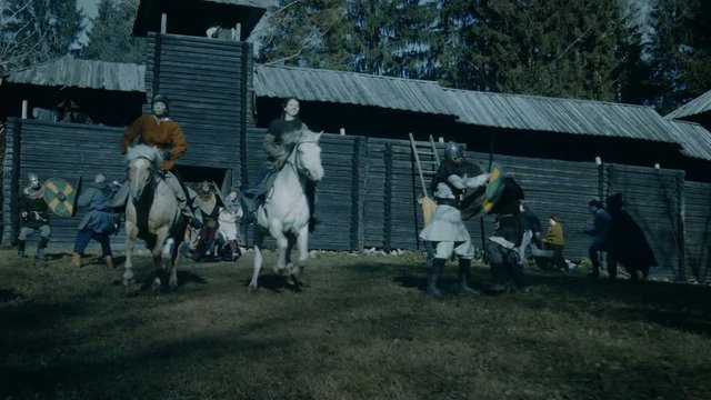 Medieval Battle Where Vikings Attack Wooder Fortress, Villagers Defend and Fight. Women on Horses Run for Their Lives. Medieval Reenactment. Shot on RED EPIC-W 8K Helium Cinema Camera.