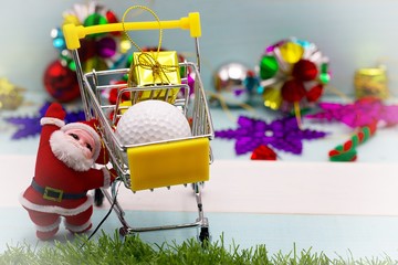 Santa with golf ball for golfer present on Christmas holiday