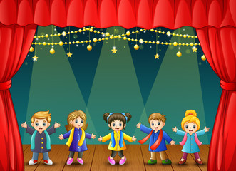 Children in winter clothes performing on stage