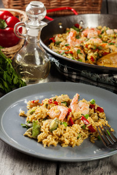 Traditional seafood paella with shrimp, fish and chicken seved in plate.