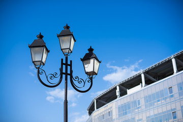 Fototapeta na wymiar street lamp near a building against the blue sky