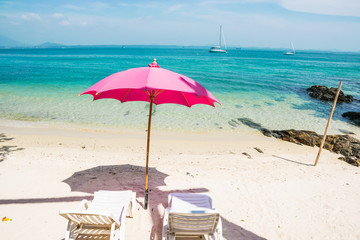 pink chairs and White umbrellas on the beach at Samed Island, Thailand.