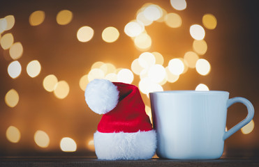 Obraz na płótnie Canvas White cup of tea or coffee and Santa Claus hat