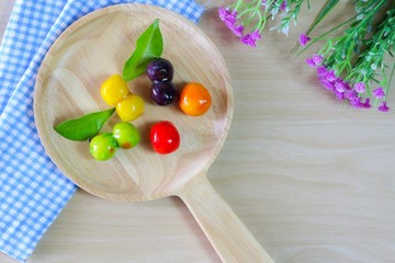 Flat lay photo with Candy coated balls on wooden Plate, Blue Cloths and flower on wooden Background