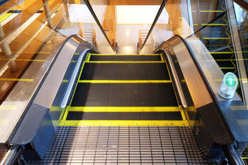 Escalator for going down direction to the ground floor with the green arrow sign on the right