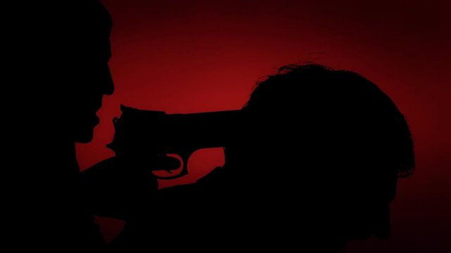 Waving nightmare: a killer (woman) pointing a handgun to the nape of a victim (man). Crime, murder, violence. Silhouette shot on red background.
